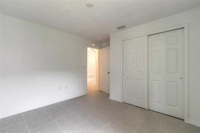 unfurnished bedroom with a closet and light tile patterned floors