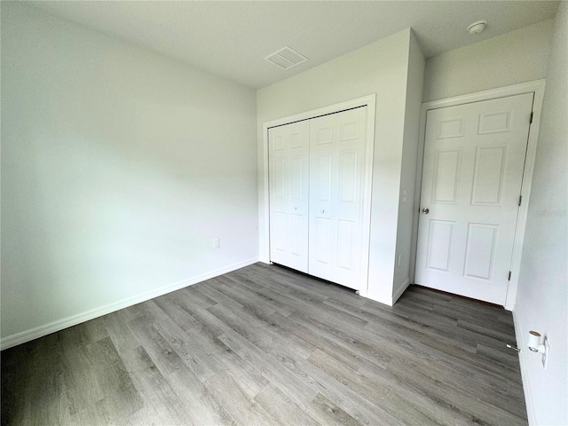 unfurnished bedroom with hardwood / wood-style flooring and a closet