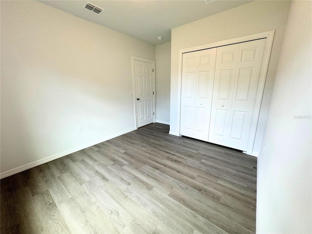 unfurnished bedroom featuring a closet and wood-type flooring