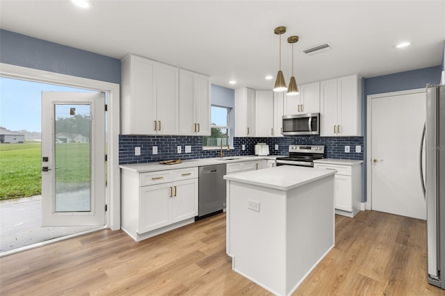 kitchen featuring a wealth of natural light, stainless steel appliances, and white cabinets