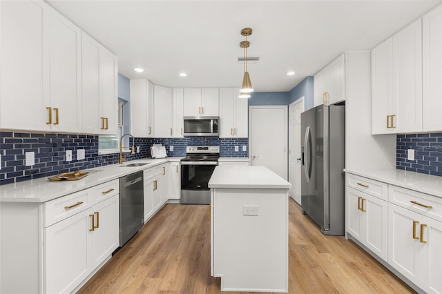 kitchen with light hardwood / wood-style floors, stainless steel appliances, sink, and a center island