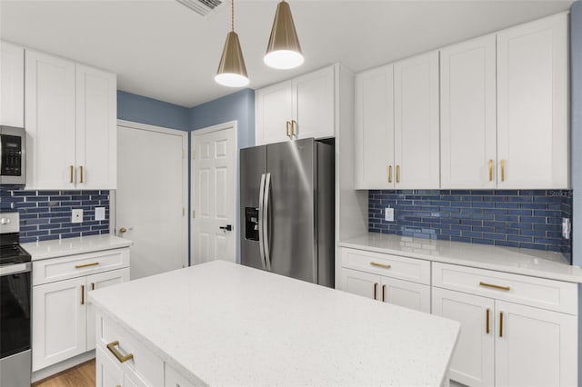 kitchen with pendant lighting, decorative backsplash, white cabinetry, and stainless steel appliances