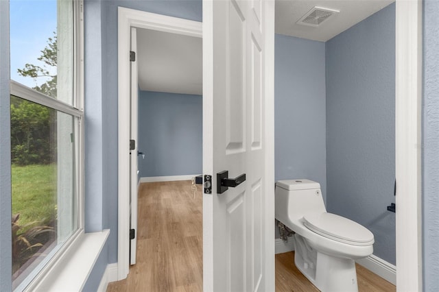 bathroom featuring wood-type flooring and toilet