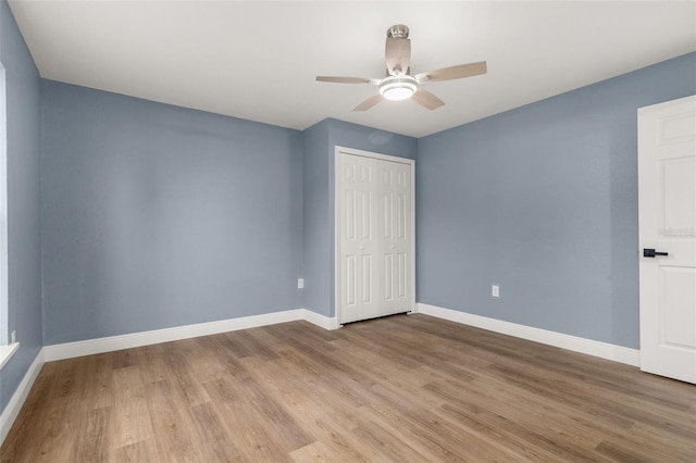 unfurnished bedroom with ceiling fan, light wood-type flooring, and a closet