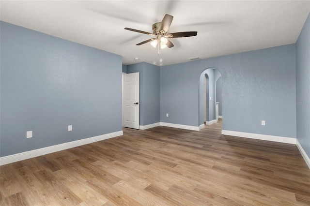 empty room with ceiling fan and light hardwood / wood-style floors