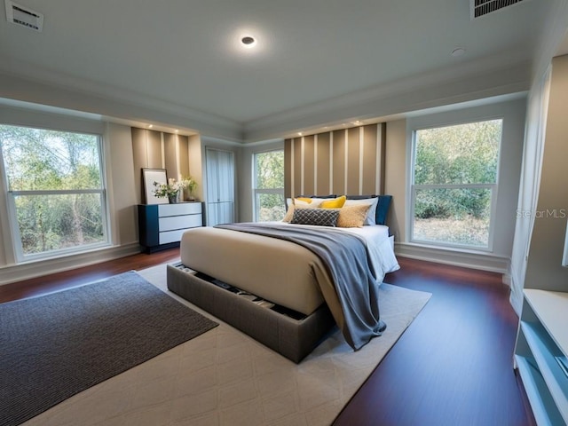 bedroom featuring crown molding, dark hardwood / wood-style floors, and multiple windows