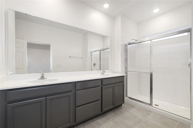 bathroom featuring a shower with shower door, tile patterned floors, and double sink vanity