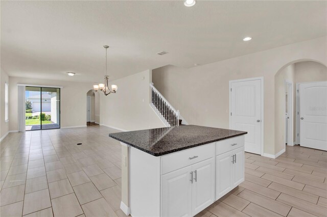 kitchen with white cabinetry, light tile patterned floors, a notable chandelier, and a kitchen island