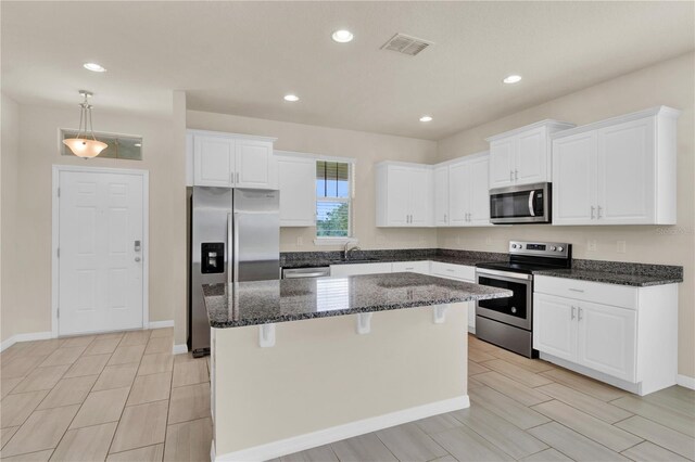 kitchen featuring sink, stainless steel appliances, pendant lighting, and white cabinets