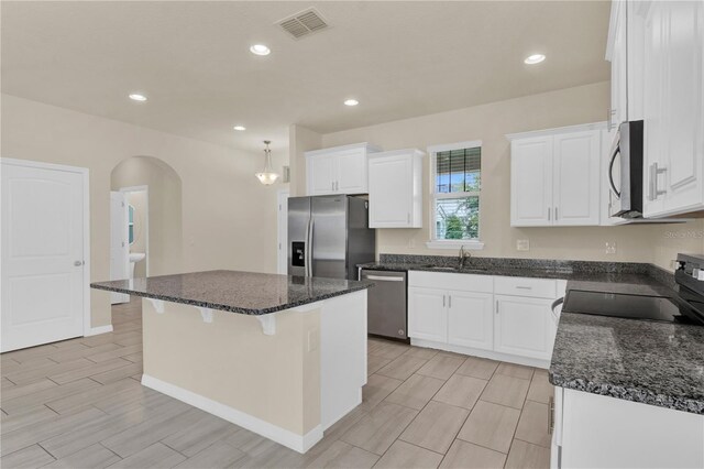 kitchen featuring white cabinets, sink, a center island, and stainless steel appliances