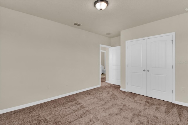 unfurnished bedroom featuring carpet flooring and a closet