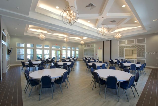 dining area with a tray ceiling, a chandelier, hardwood / wood-style flooring, and coffered ceiling