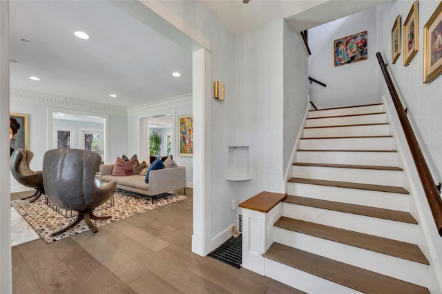 stairway featuring baseboards, wood finished floors, and recessed lighting