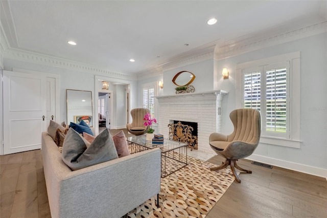 living area with a fireplace, wood finished floors, visible vents, and baseboards