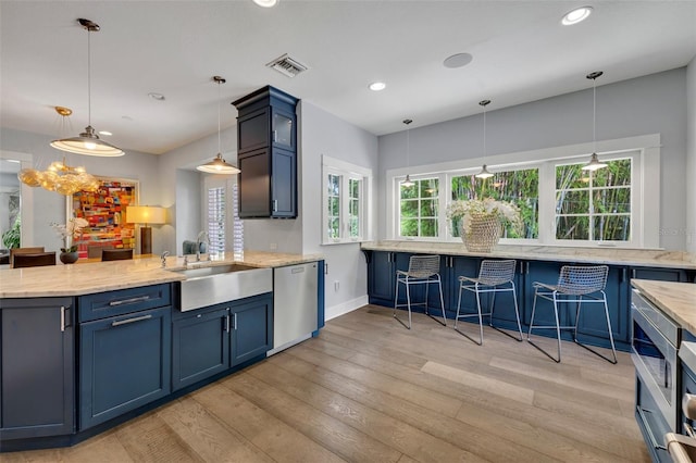 kitchen with hanging light fixtures, stainless steel dishwasher, visible vents, and blue cabinets