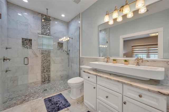 full bath featuring toilet, vanity, tile walls, marble finish floor, and a stall shower