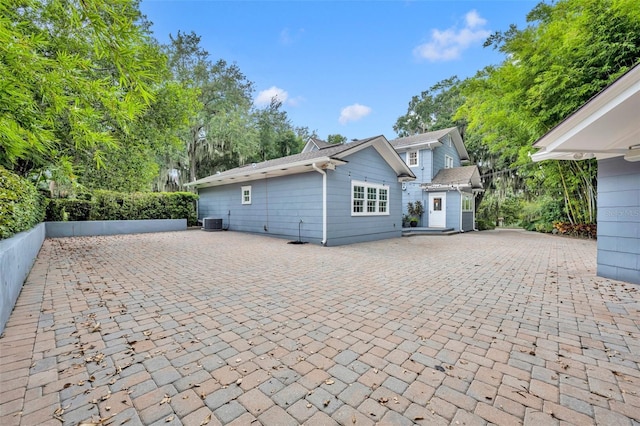 view of front of home featuring a patio area, central AC, and fence