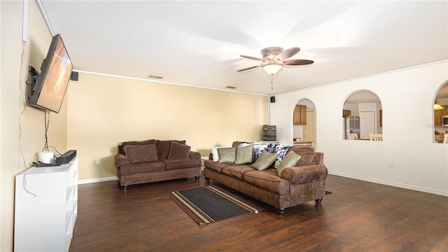 living room featuring ceiling fan, dark wood-type flooring, and crown molding