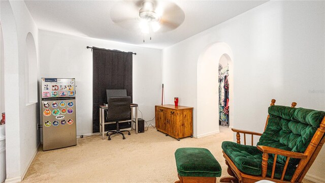 living area with ceiling fan and light colored carpet