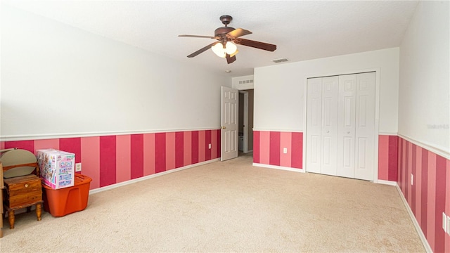 interior space with carpet floors and ceiling fan