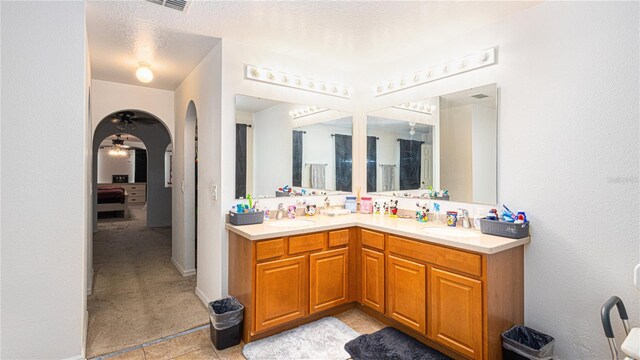 bathroom with tile patterned floors, a textured ceiling, and double vanity