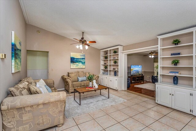 tiled living room featuring ceiling fan, a textured ceiling, and vaulted ceiling