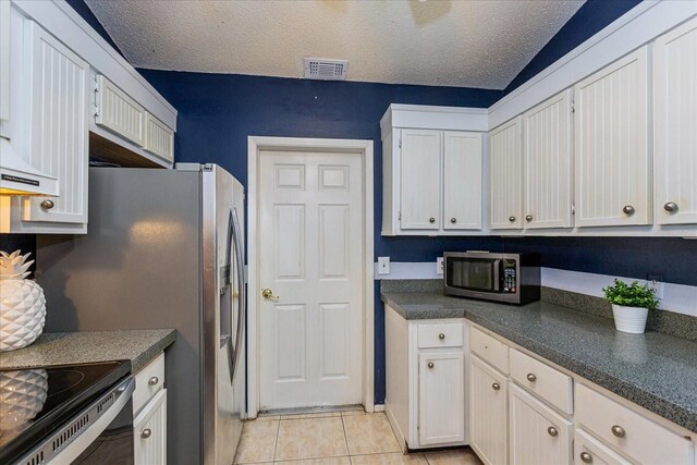 kitchen featuring white cabinets, a textured ceiling, and light tile patterned floors