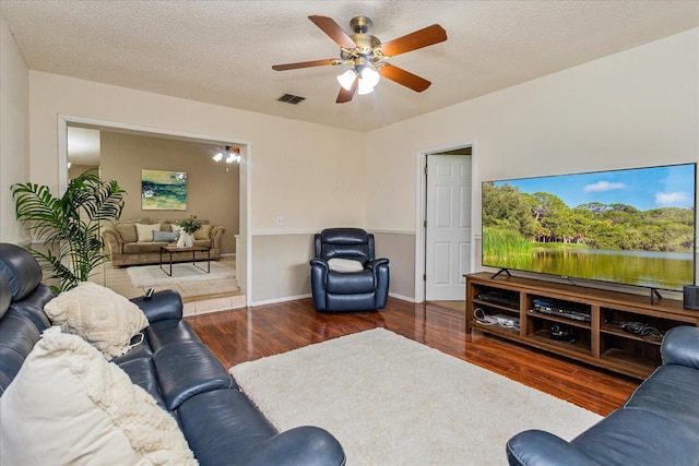 living room featuring ceiling fan, a textured ceiling, and hardwood / wood-style floors