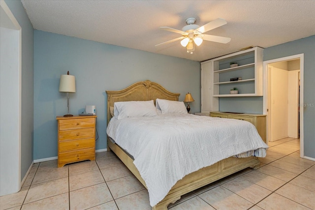 tiled bedroom featuring ceiling fan and a textured ceiling