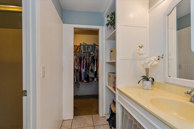 bathroom with vanity, a textured ceiling, and tile patterned flooring