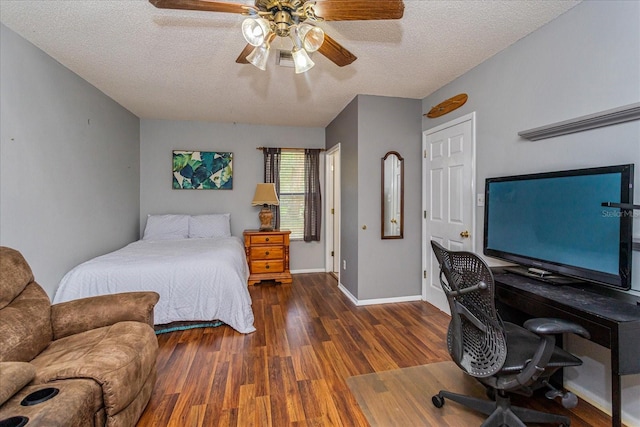 bedroom with a textured ceiling, ceiling fan, and dark hardwood / wood-style flooring