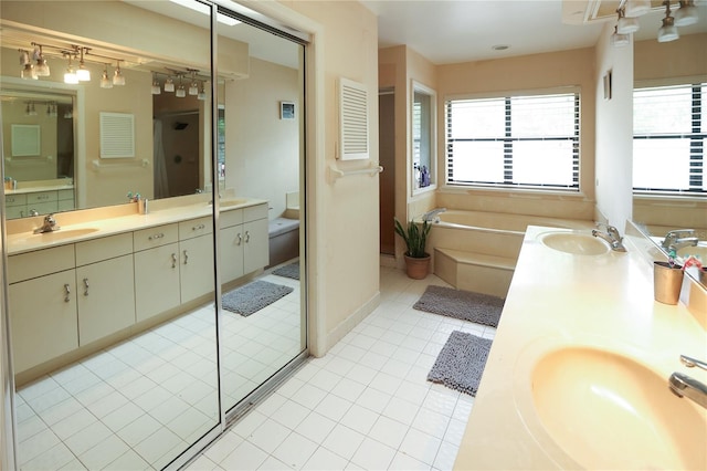 bathroom featuring a tub, dual bowl vanity, and tile patterned floors