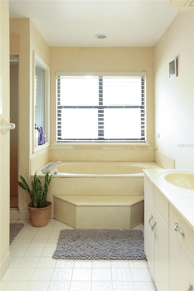 bathroom with a bath, tile patterned floors, and vanity