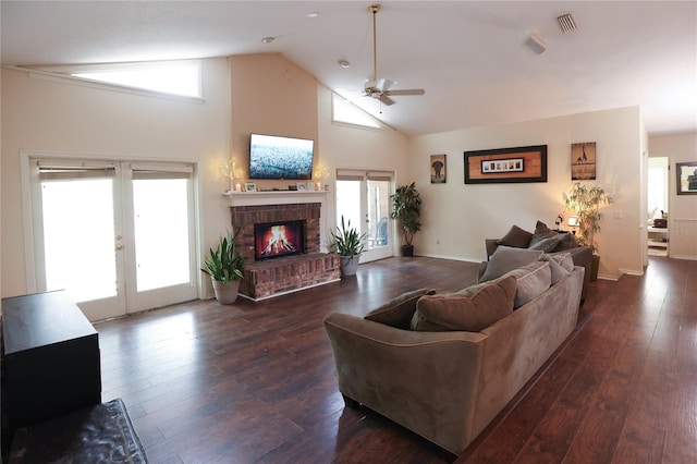 living room featuring a fireplace, ceiling fan, a healthy amount of sunlight, and dark hardwood / wood-style flooring