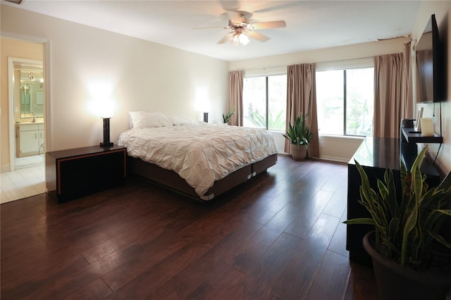 bedroom featuring ceiling fan, dark hardwood / wood-style floors, and connected bathroom