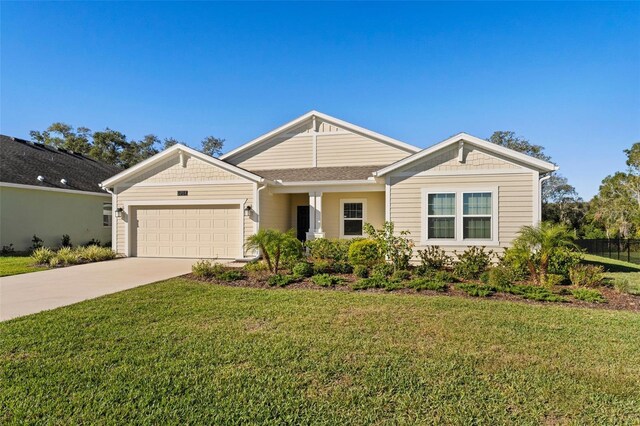 view of front facade featuring a garage, a front yard, and concrete driveway