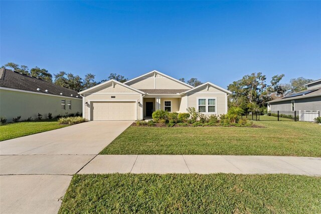 view of front of property with a garage, concrete driveway, a front yard, and fence