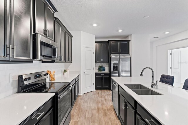 kitchen with appliances with stainless steel finishes, light countertops, and a sink