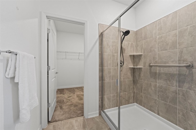 full bathroom featuring a shower stall and a spacious closet