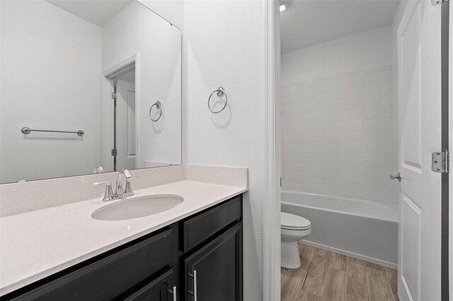 bathroom featuring vanity, wood finished floors, and toilet