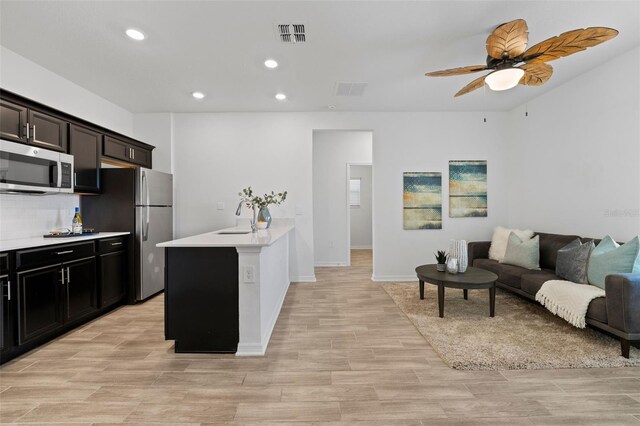 kitchen with visible vents, stainless steel appliances, light countertops, and open floor plan