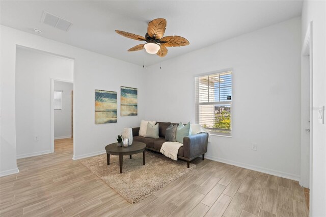 sitting room featuring baseboards, visible vents, ceiling fan, and light wood finished floors