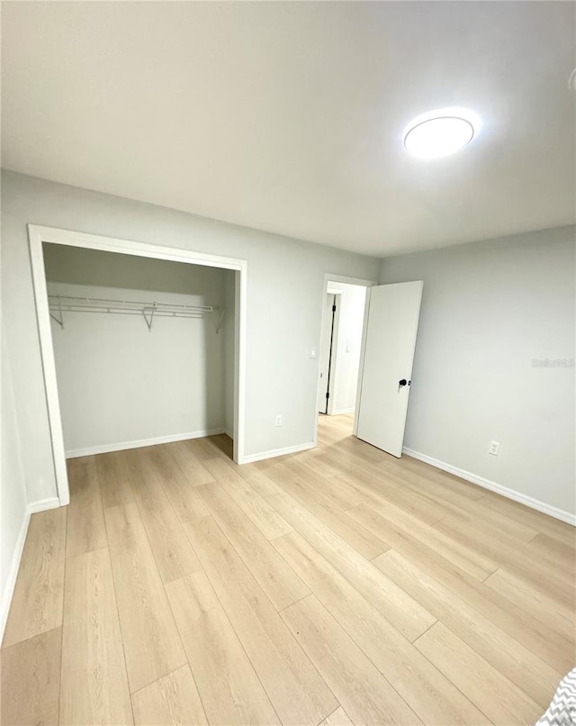 unfurnished bedroom featuring light hardwood / wood-style flooring and a closet