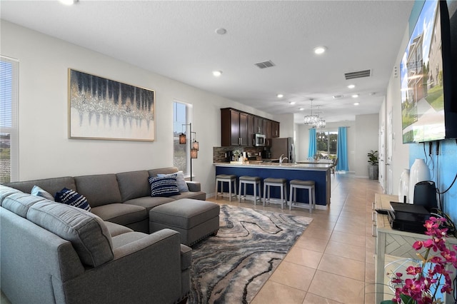 tiled living room featuring a chandelier