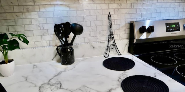 interior details with light stone counters and electric range