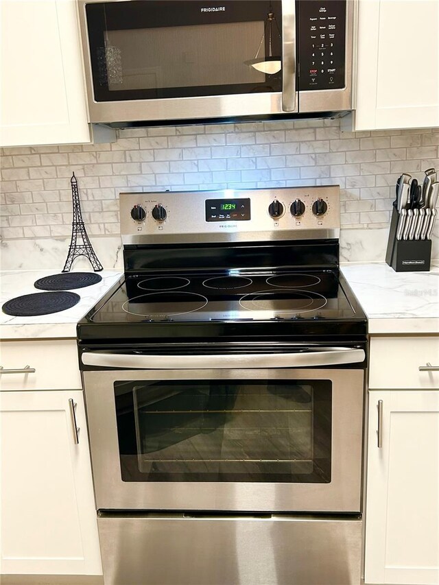 kitchen featuring white cabinets, decorative backsplash, and appliances with stainless steel finishes