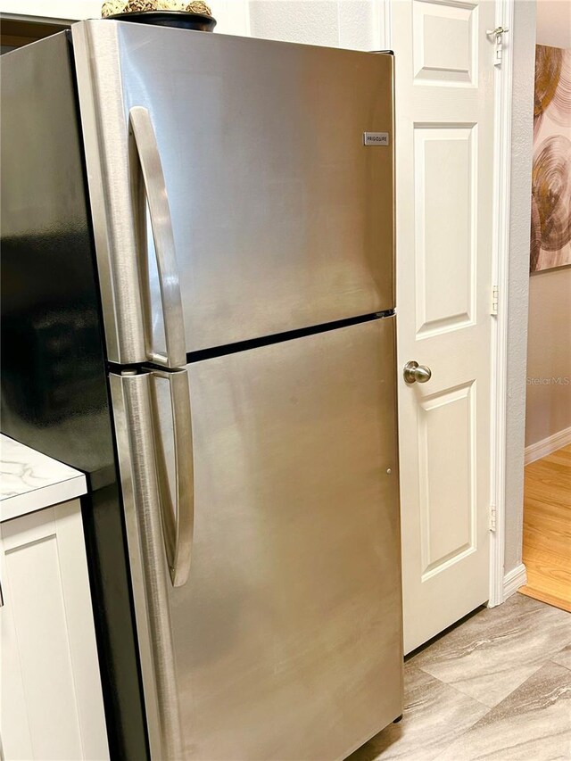 kitchen with stainless steel refrigerator and light hardwood / wood-style flooring