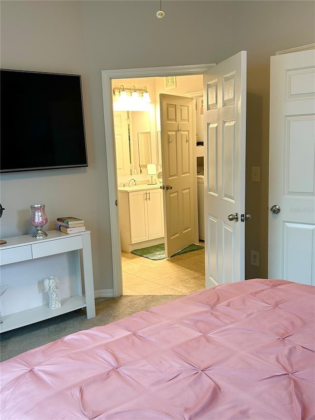 1990 Erving Cir Unit 201, Ocoee, FL 34761 - bedroom featuring washer / dryer, connected bathroom, a sink, baseboards, and light colored carpet