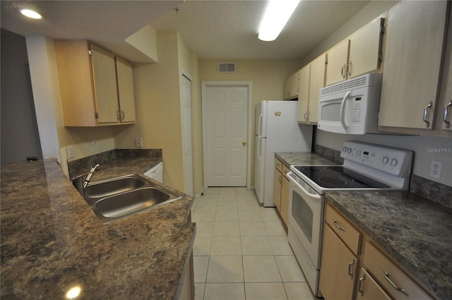 kitchen featuring light tile patterned flooring, white appliances, a textured ceiling, light brown cabinetry, and sink