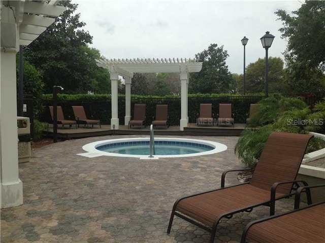 view of pool with a wooden deck, fence, a pergola, and a hot tub